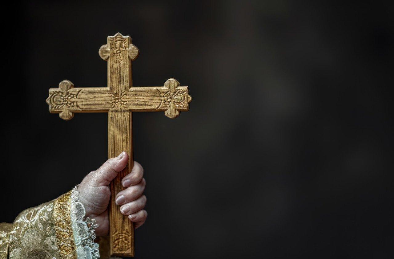 A female hand holding wooden cross