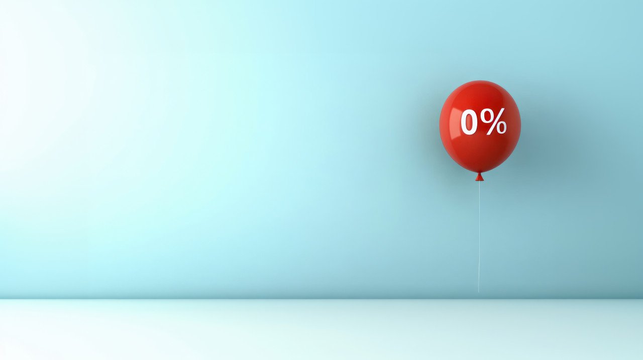 A red balloon with the text 0% floating against a light blue wall credit ratings concept