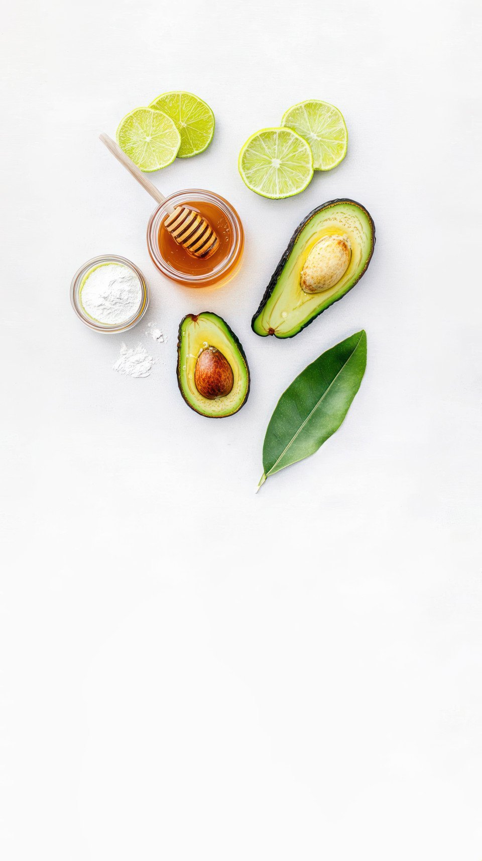 Aerial view of avocado and honey face mask ingredients featuring avocados lime slices