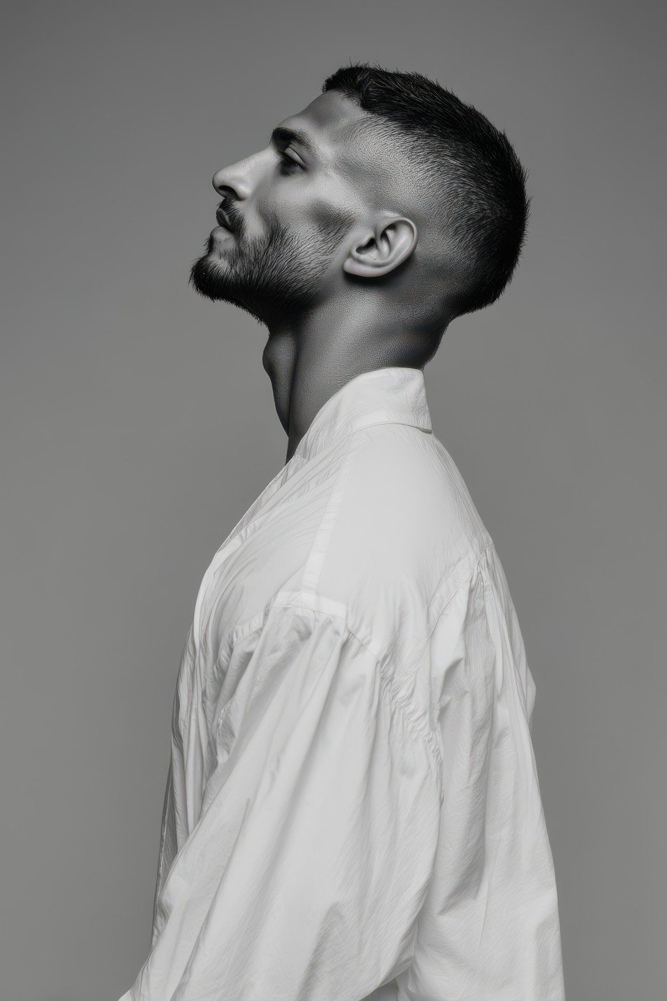 Youthful model in white tunic stands in profile